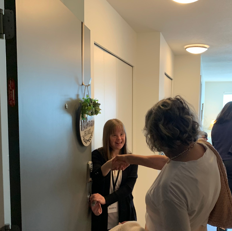 Self Advocate Krista Milne welcomes guests into her apartment at Chorus, UNITI's Affordable Housing Apartments built in 2016.